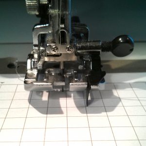 I needed to be a little better here about making sure the line was lined up with the edge of my presser foot, but you can see just how off my needle position is. I'll need to adjust alot, so I will move it several ticks at a time. This eventually went from 3.7 to 5.9.